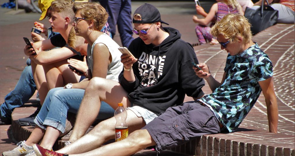 Various youths browse smartphone apps